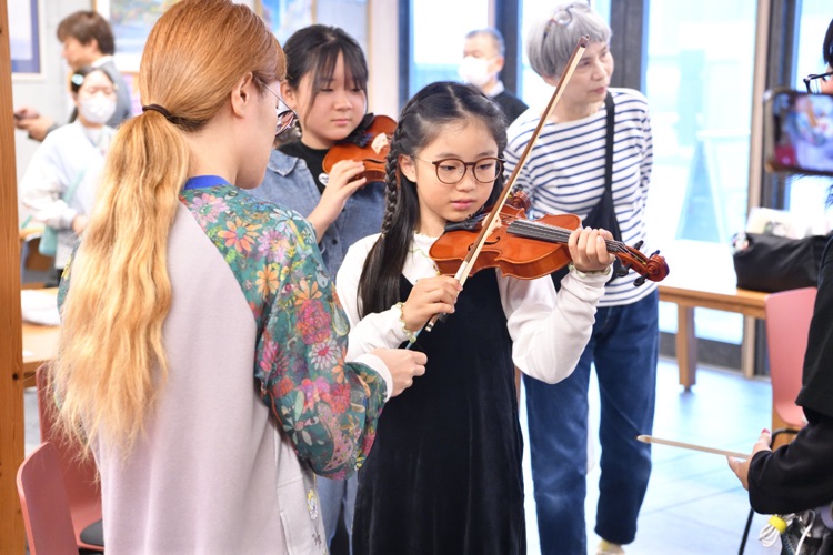 楽器体験の様子。子どもがヴァイオリンを弾いている